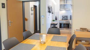 Un comedor con una mesa de madera, cuatro sillas y dos individuales.