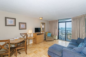 Relax in this stylish living area with a sofa, dining table, and television.