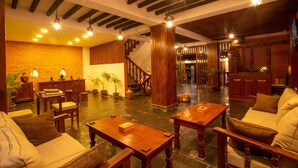 Un vestíbulo amplio con muebles de madera, una escalera y una pared de ladrillo.