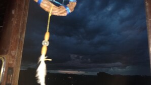 A dreamcatcher hanging from a wooden structure.