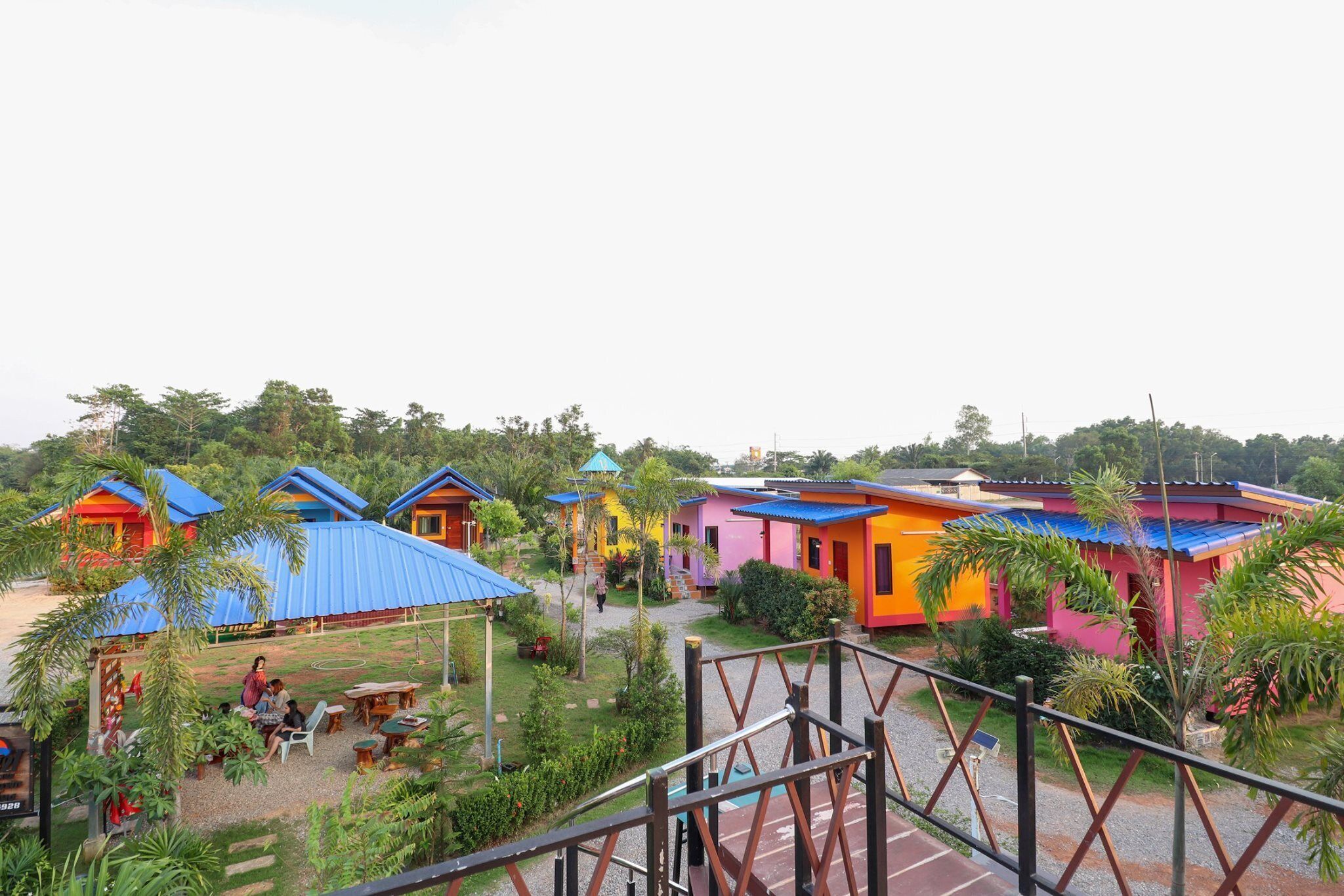 De jolies maisons aux couleurs vives, avec des toits bleus, un espace salon abrité et un chemin de gravier.
