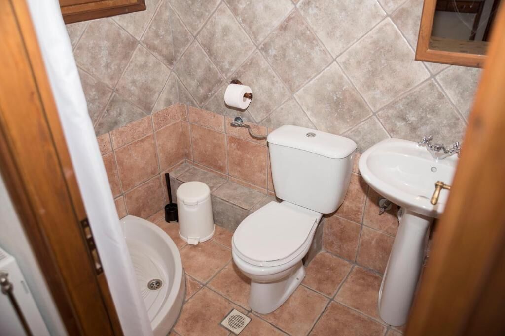 Une petite salle de bain avec des toilettes, un lavabo et une poubelle.
