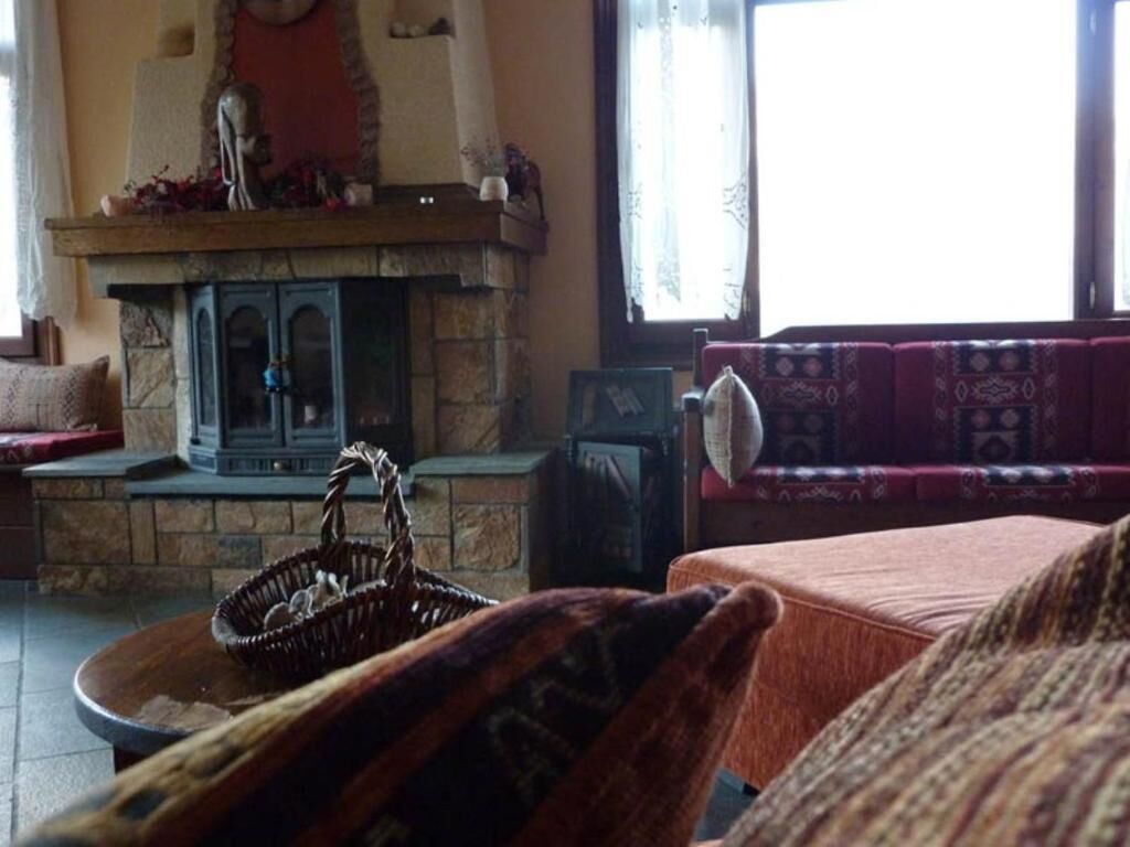 A cozy living room with a stone fireplace, a sofa, and a table with a basket.