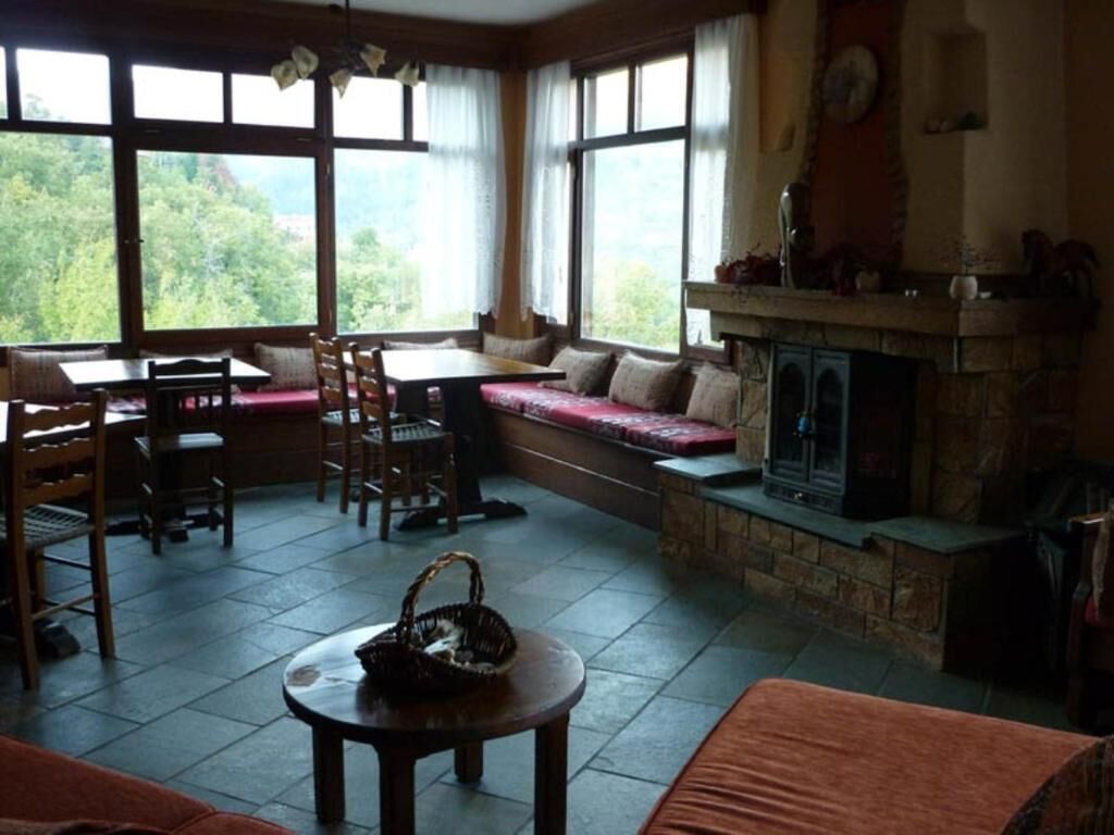 Una sala de estar acogedora con chimenea, ventanas amplias y un área de descanso.