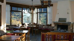 Una sala de estar acogedora con chimenea, ventanas amplias que ofrecen una vista panorámica y zonas de estar cómodas.
