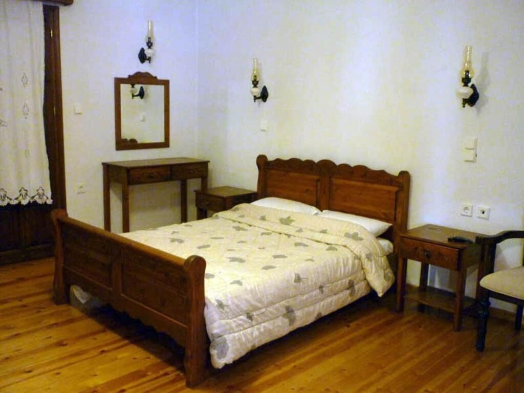 A bedroom with a wooden bed, a nightstand, a dresser, and a chair.
