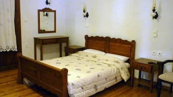 A bedroom with a wooden bed, a nightstand, a dresser, and a chair.