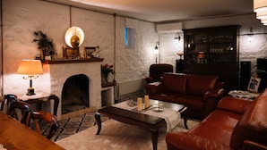 Una sala de estar acogedora con chimenea, sofá de cuero y una mesa de centro.