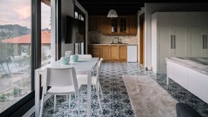 Una cocina moderna con armarios de madera, una encimera blanca y un comedor con mesa y sillas.