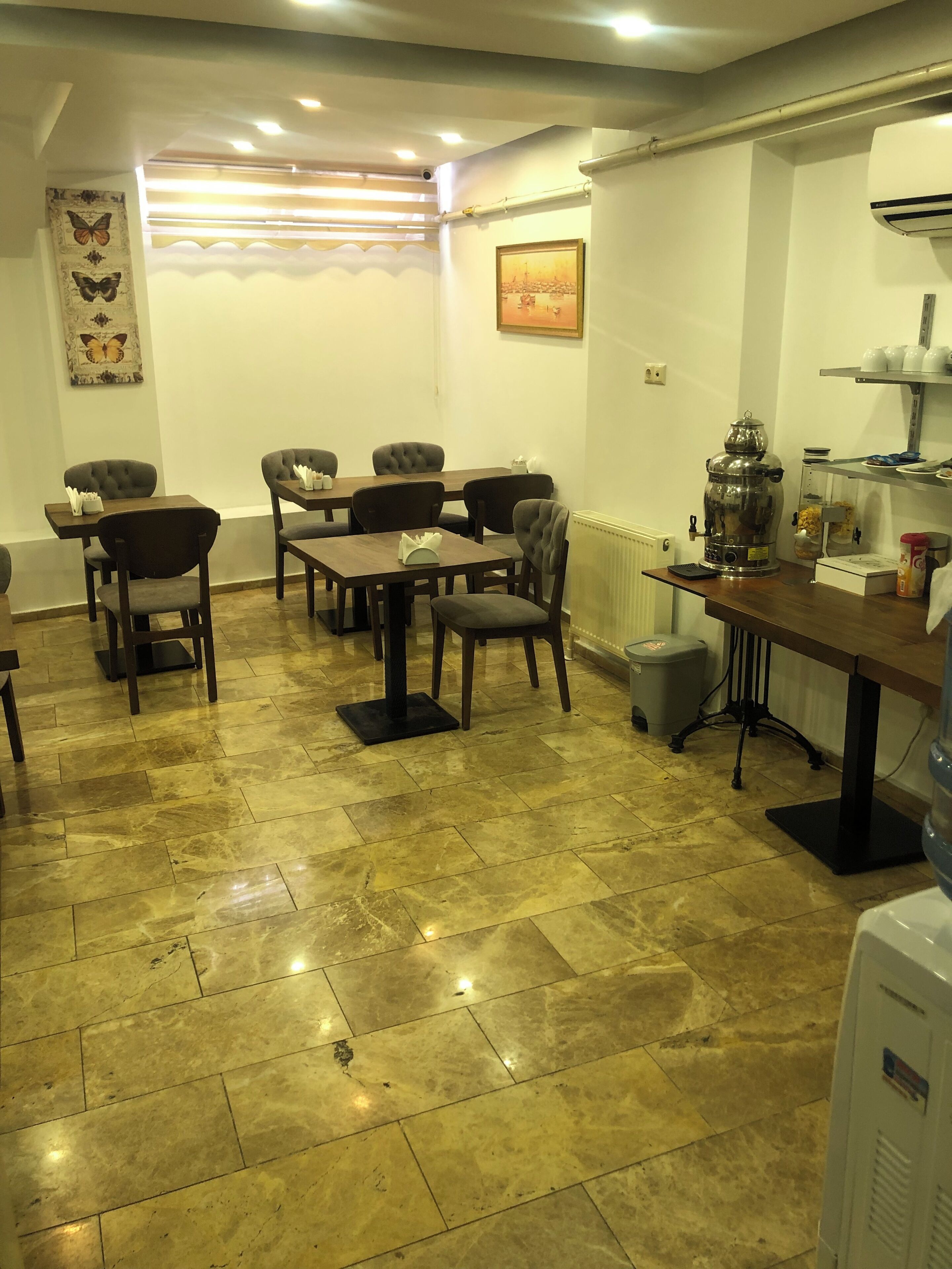 Un coin repas avec une table et des chaises, un radiateur et une grande machine à café.