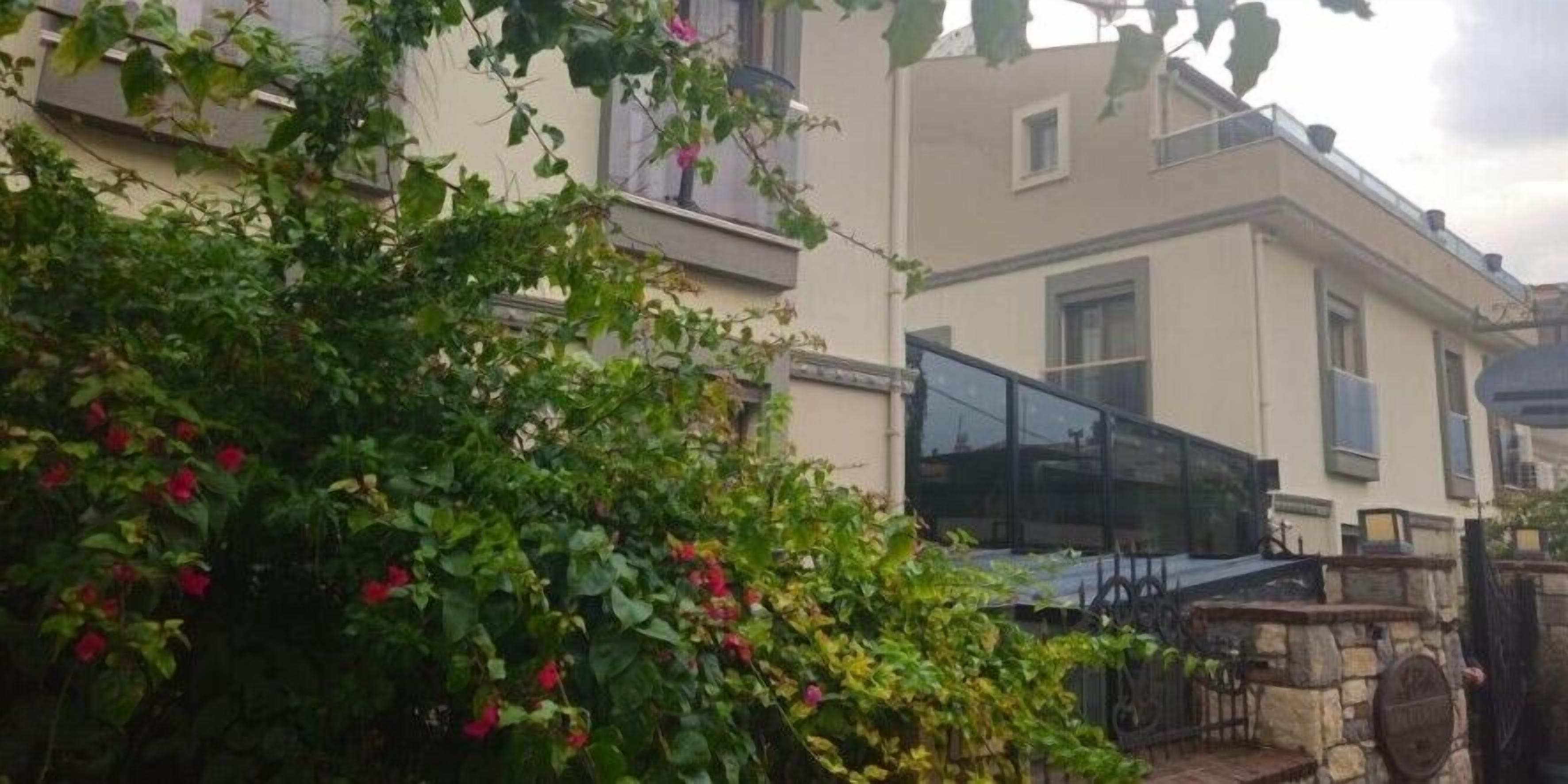 Un edificio residencial con un muro de piedra y una reja de metal.