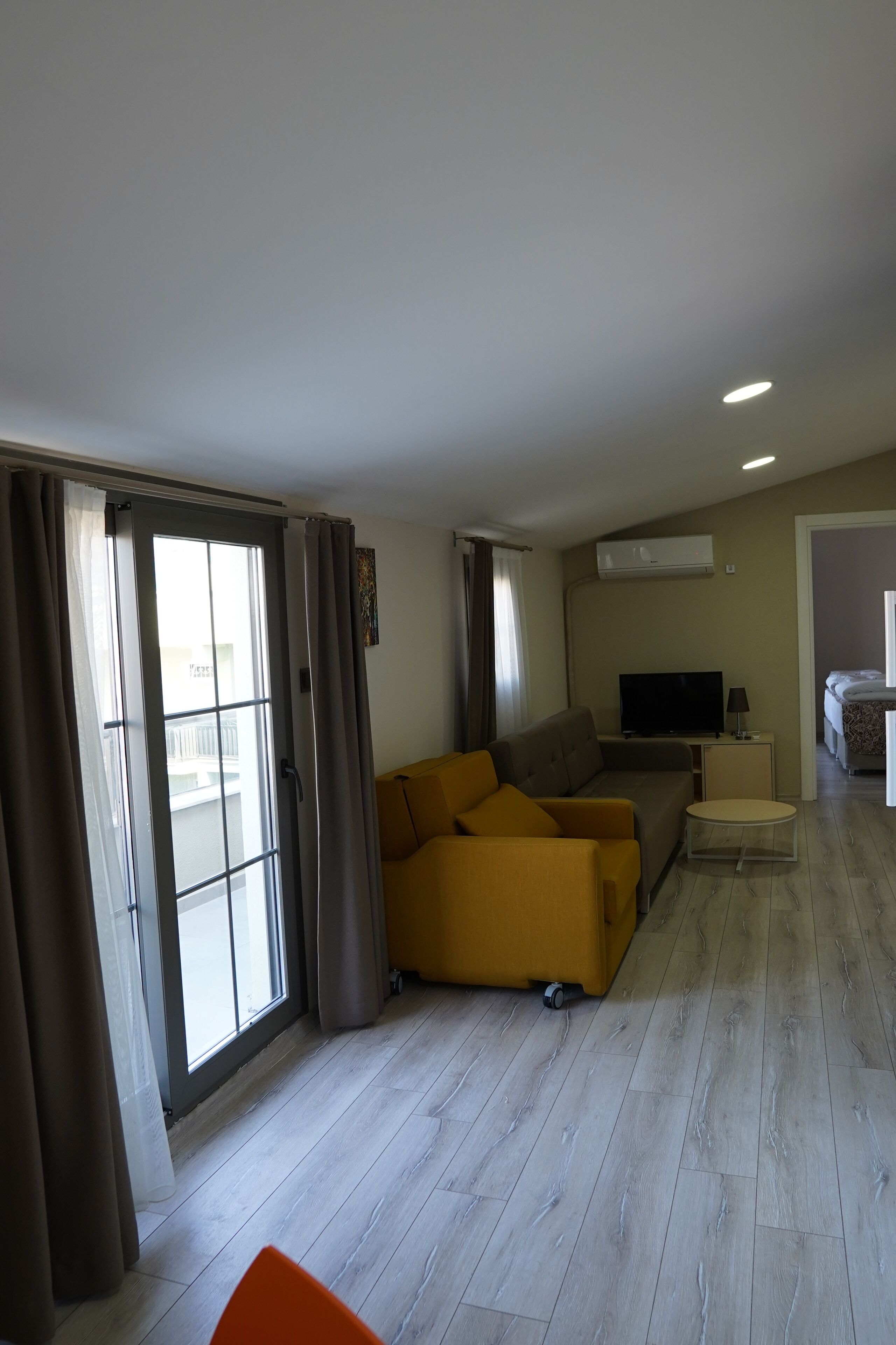 Una sala moderna con un sofá, un televisor y una mesita.