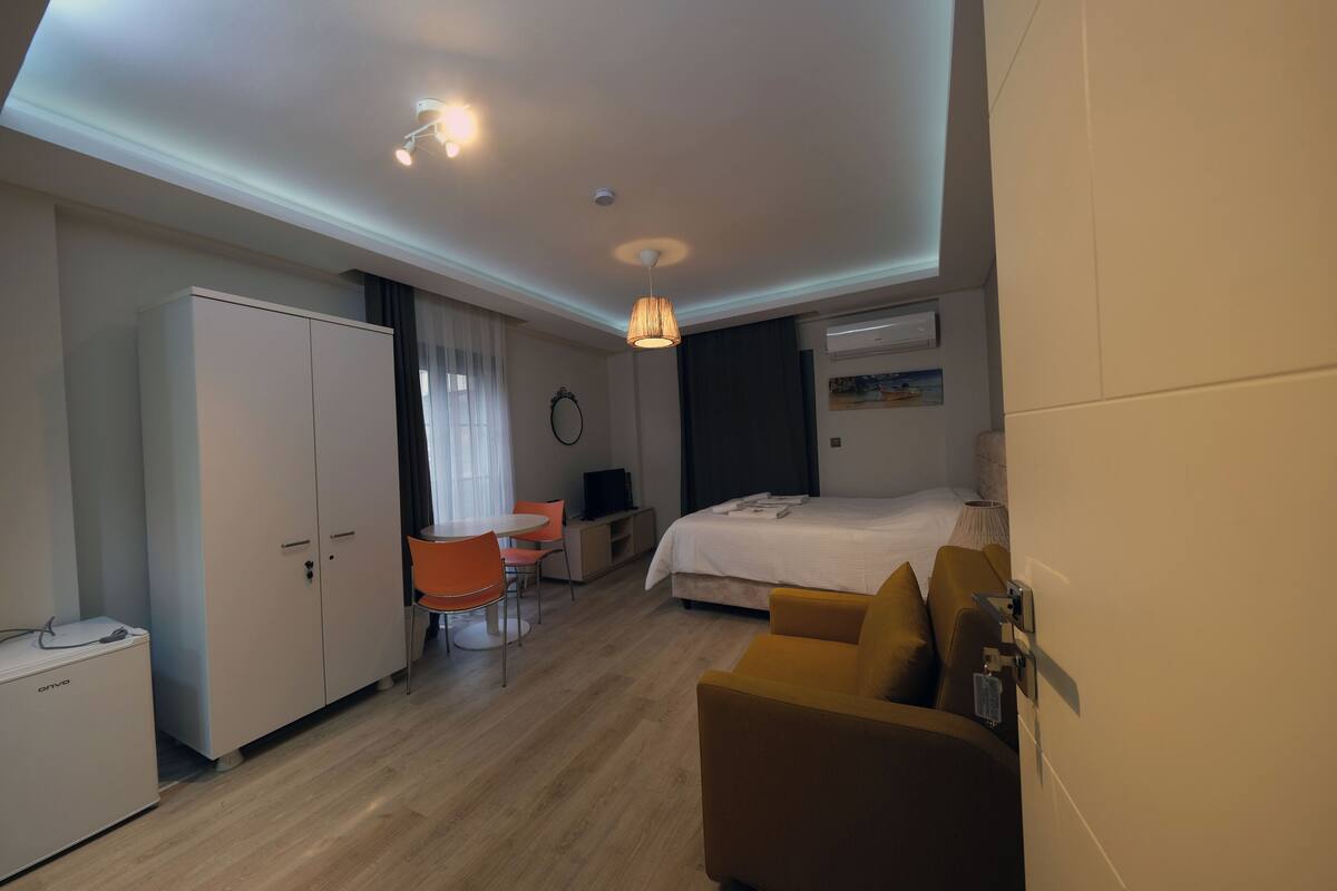 Une chambre d’hôtel comprenant un lit, un bureau avec une chaise, une armoire et un téléviseur.