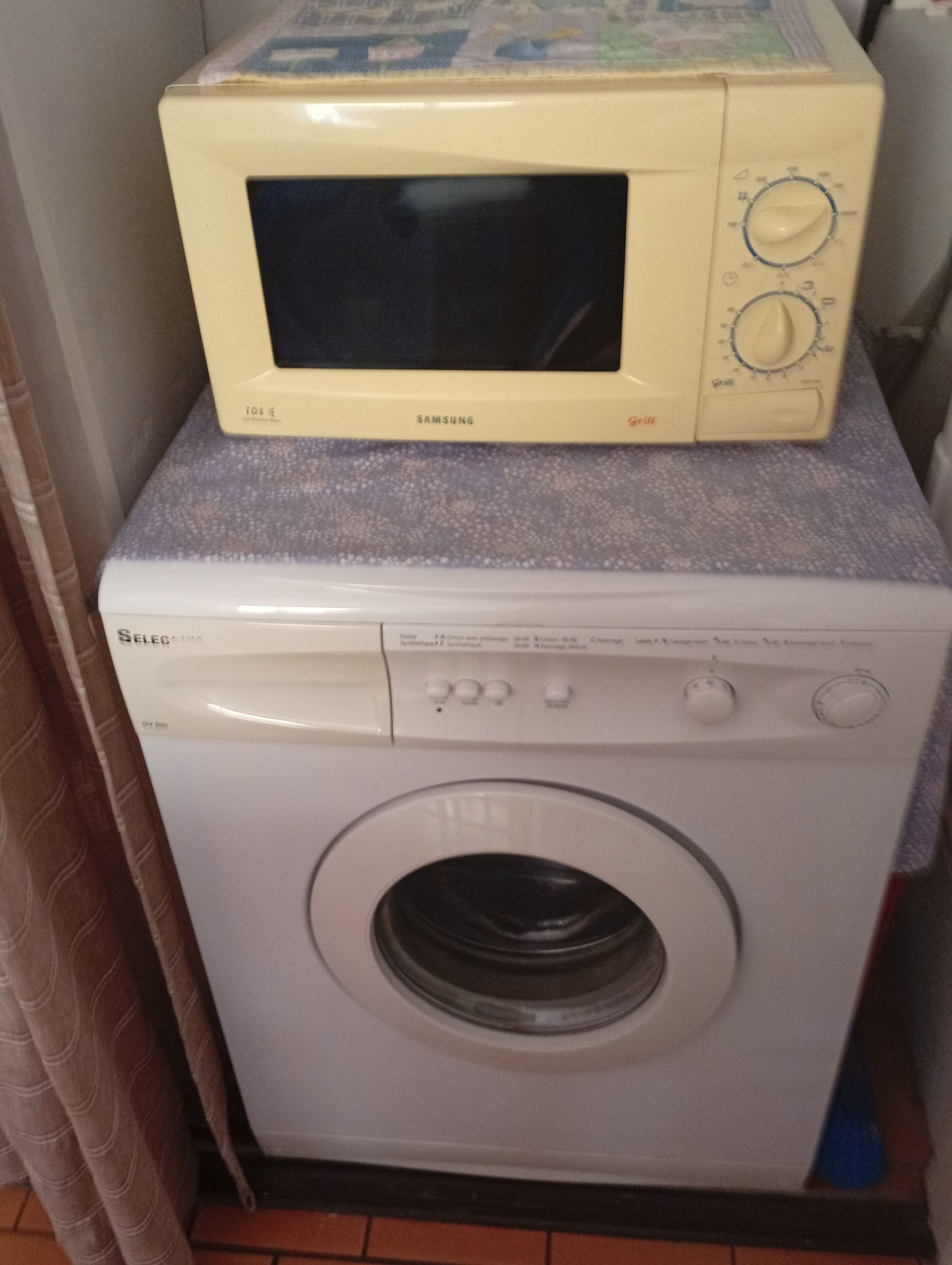 A washing machine and a microwave stacked on top of each other.