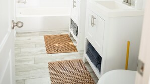 Ein Badezimmer mit einer Badewanne, zwei Waschbecken und einer Toilette.