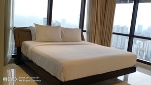 A modern hotel room with a large bed, a view of the cityscape through large windows, and a minimalist design. - Times Square Residence At Kuala Lumpur (Kuala Lumpur)