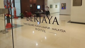 The interior of the Berjaya Hotel, Times Square, Kuala Lumpur, Malaysia, with a reception area, seating, and artwork on the walls. - Times Square Residence At Kuala Lumpur (Kuala Lumpur)