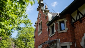Ein Gebäude aus roten Ziegelsteinen mit einem Giebeldach und einem markanten Schornstein.