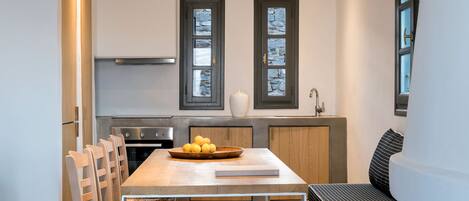 Une cuisine moderne avec un coin repas, des appareils électroménagers intégrés et un banc.