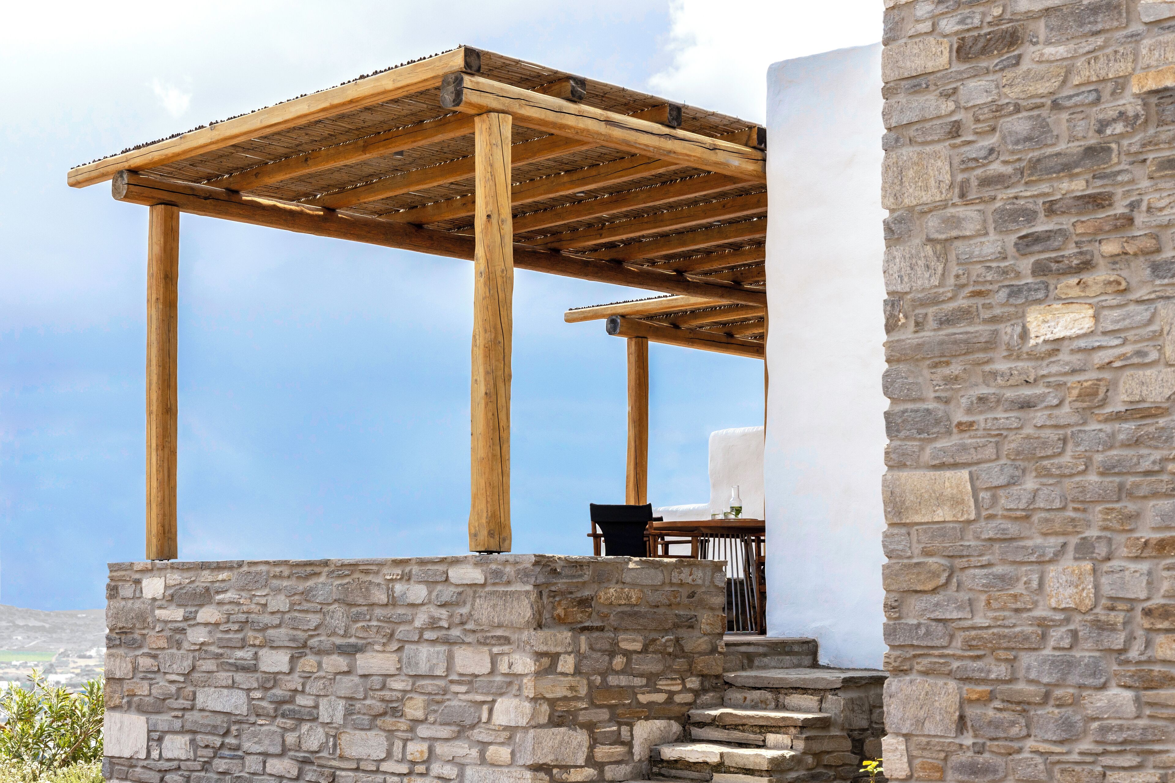 A stone building with a wooden pergola structure.