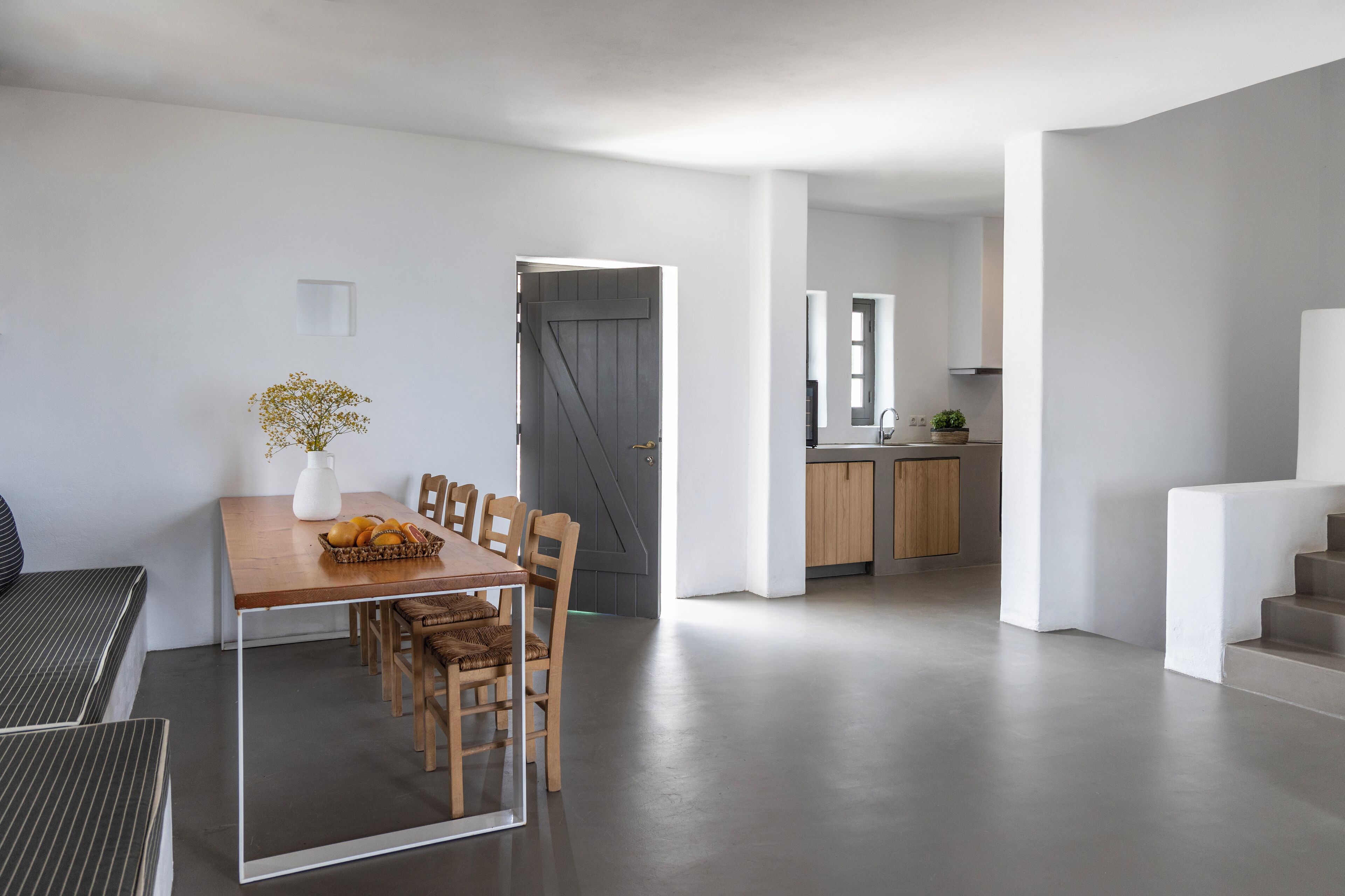Un intérieur moderne comprenant un espace repas, une cuisine et un escalier.