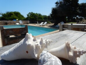 A wooden deck with a pool and lounge chairs in the background. - Eco Resort Bonaire (Kralendijk)