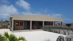 A modern building with a flat roof, large windows, and a covered outdoor area with a cactus garden. - Eco Resort Bonaire (Kralendijk)