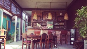 Un comedor acogedor con muebles de madera, un tapete estampado y lámparas colgantes.