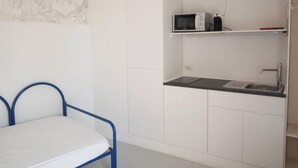 A compact kitchenette with a microwave, a sink, and a small shelf. - Eremo di Montevergine : Calipso, cozy apartment with panoramic view (Forio)