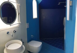A bathroom with a white sink, a toilet, a shower, and a window. - Eremo di Montevergine : Calipso, cozy apartment with panoramic view (Forio)
