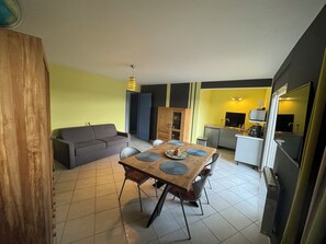 Cozy living space with a dining area, sofa, and kitchenette.