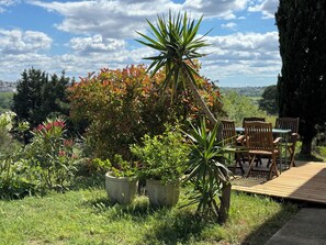 Relax in a serene outdoor space surrounded by lush greenery and a clear blue sky.
