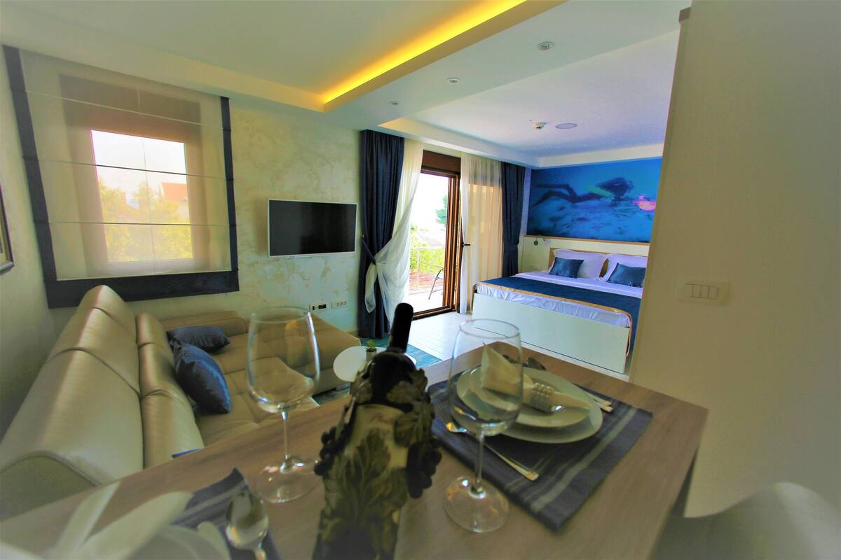 Luxury-Studio, Meerblick | Wohnbereich | 35-Zoll-Flachbildfernseher mit Kabelempfang, Fernseher