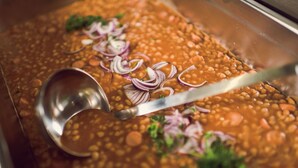 Close-up de um prato com feijão, cebola e salsa.