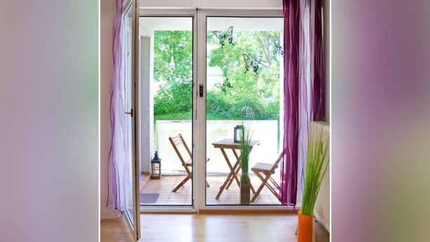 A room with a sliding glass door leading to an outdoor patio with a table and chairs.