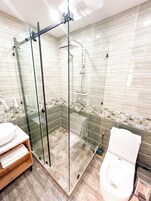 Quarto casal com design assinado | Banheiro | Chuveiro, secador de cabelo, chinelos, toalhas de banho