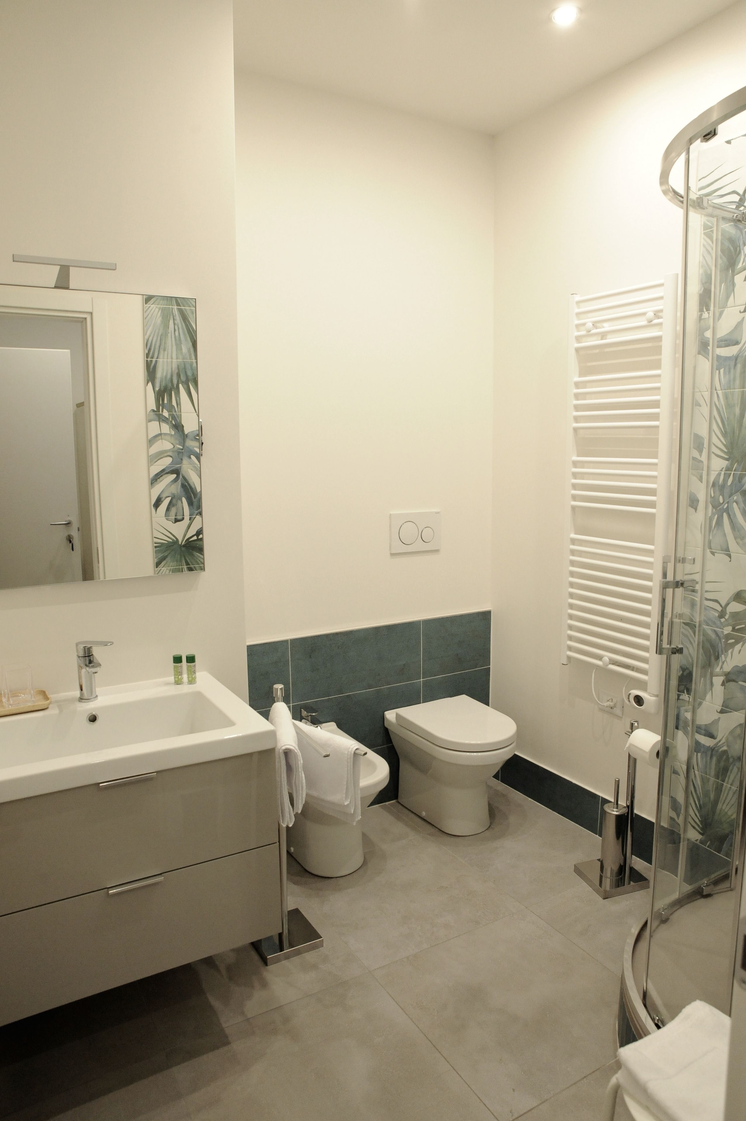 Une salle de bain moderne équipée d’un lavabo, de toilettes et d’une douche.