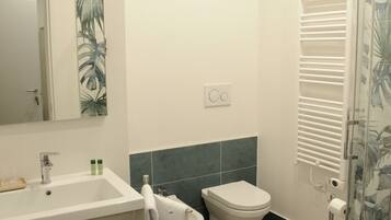 Une salle de bain moderne équipée d’un lavabo, de toilettes et d’une douche.