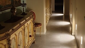 A hallway with a decorative cabinet and a painting on the wall. - Milano Dreams (Milan)