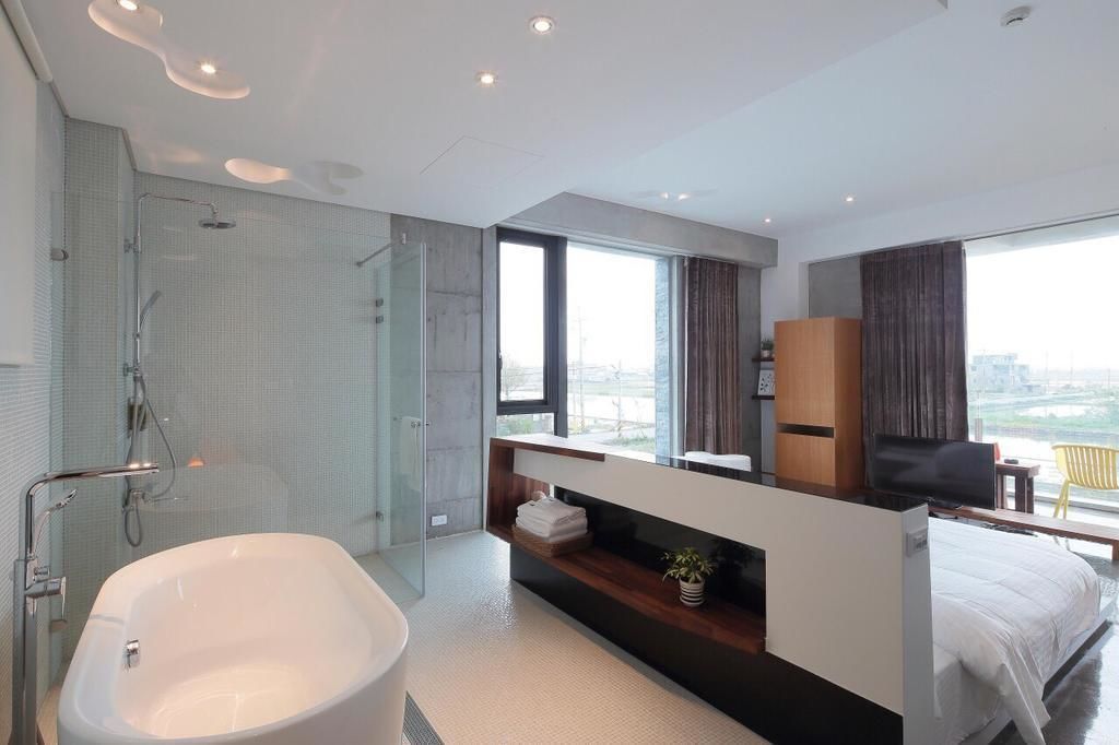 A modern bathroom with a freestanding bathtub, a glass-enclosed shower, and a vanity with a mirror.