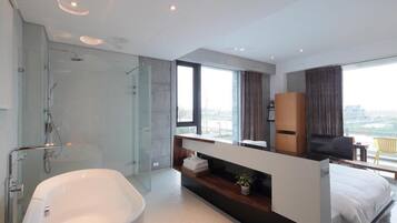 A modern bathroom with a freestanding bathtub, a glass-enclosed shower, and a vanity with a mirror.