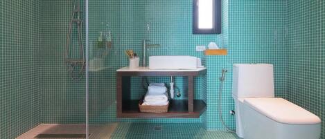 Un baño con ducha, inodoro y lavabo.