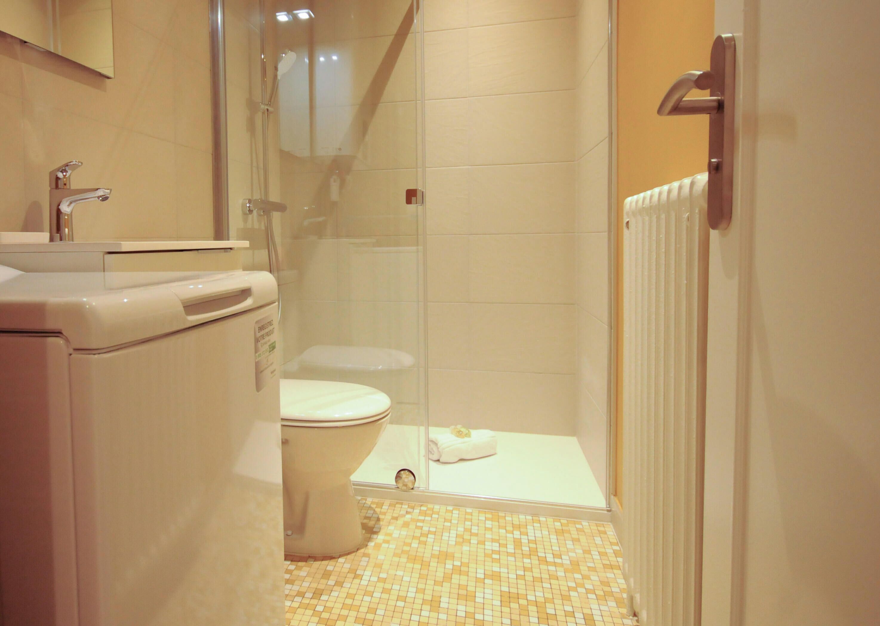 A bathroom with a toilet, sink, and shower area.