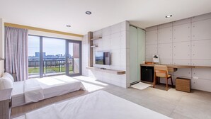 A modern hotel room with a large window, a bed, a desk, and a TV. - Sharp bnb (Magong)