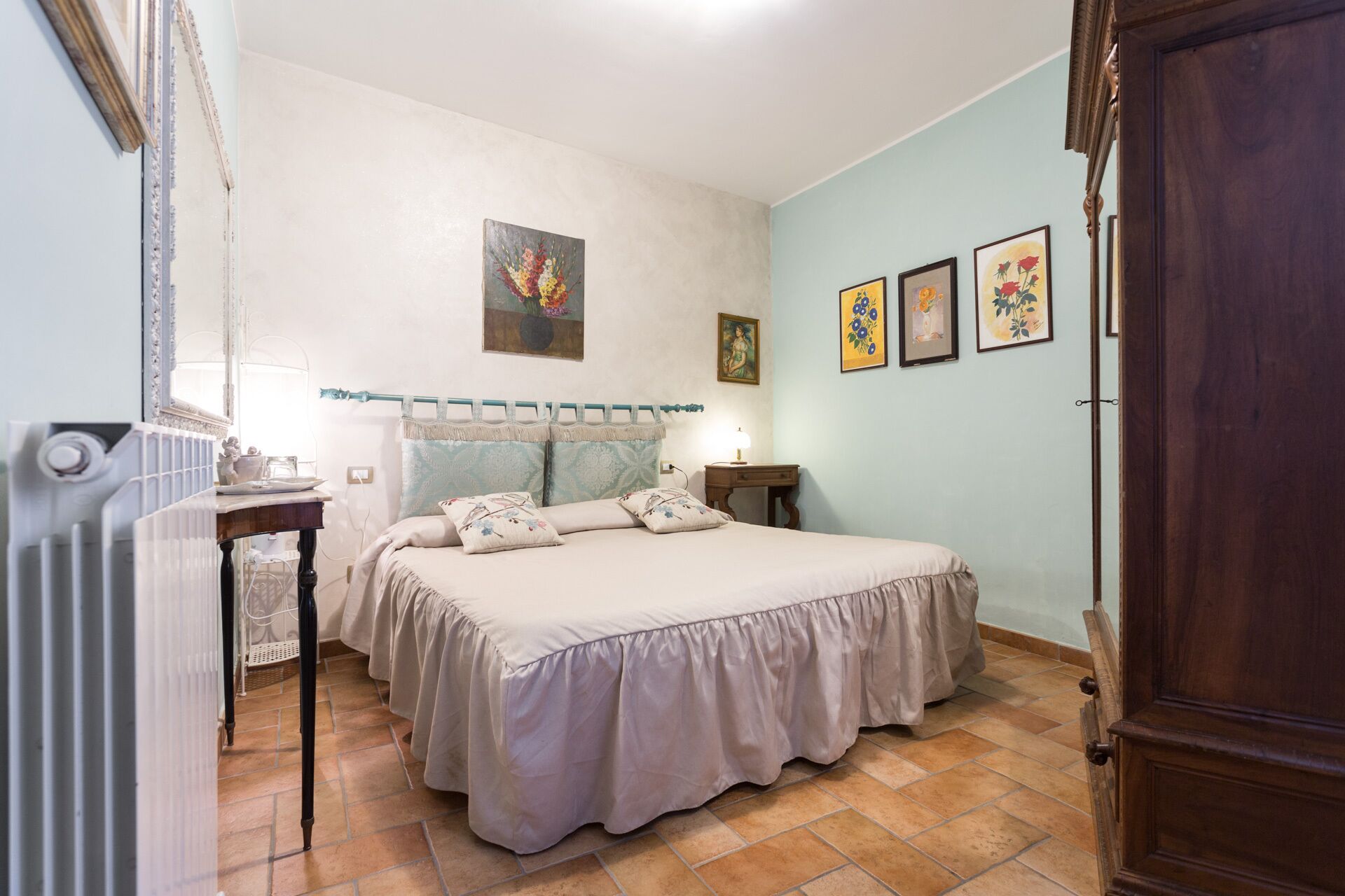 Una camera da letto con un letto, un comodino, una lampada e una porta in legno.