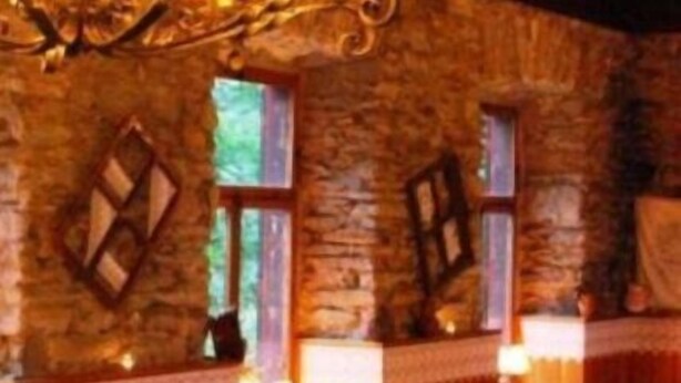 A rustic room with stone walls, wooden trim, and a chandelier. - Alpenhaus Kesselfall (Kaprun)