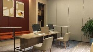 A modern office space with two desks, two chairs, a sofa, and abstract wall art. - Pullman Suzhou Zhonghui (Suzhou)