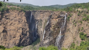 A large waterfall cascading down a rocky cliff surrounded by lush greenery. - Paradise Wild Hills (Hosanagara)