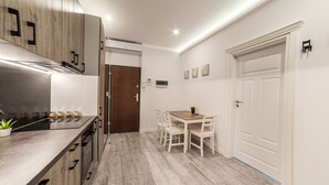Una cucina moderna con piano cottura integrato, mobili in legno e zona pranzo con tavolo e sedie.