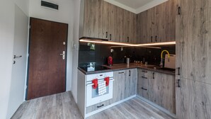 Una cucina moderna con mobili in legno, forno a incasso e lavello in acciaio inossidabile.